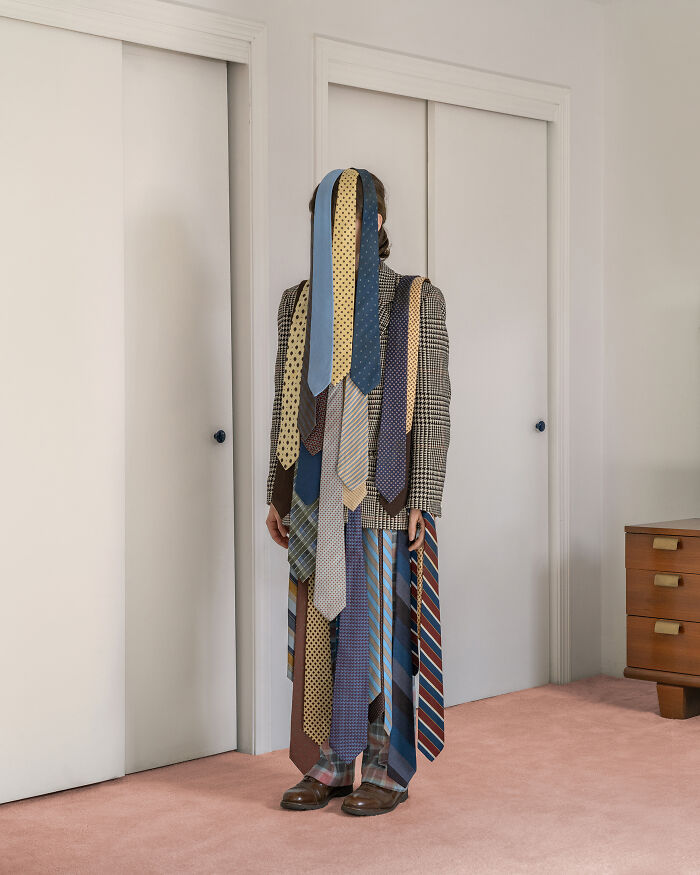 Surreal images: A person covered in various ties stands in a room, creating an uncanny and unusual everyday scene.