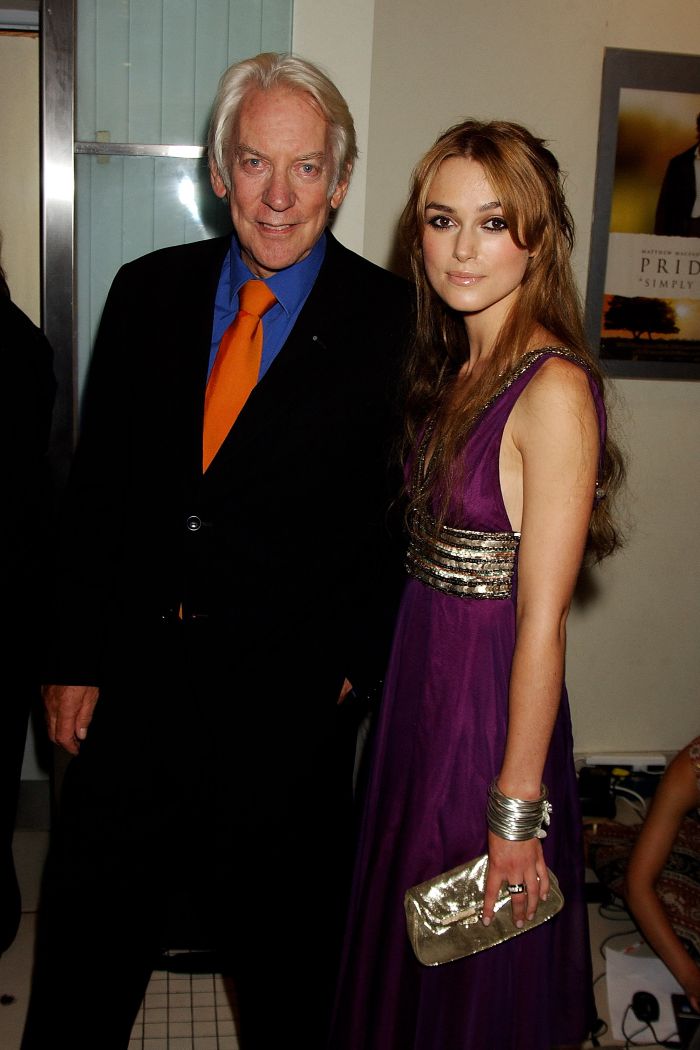 Donald Sutherland and Keira Knightley pose together at an event, both looking at the camera.