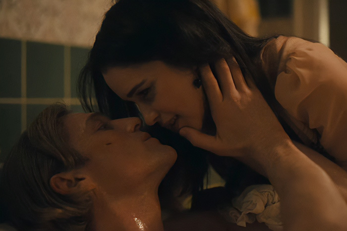 A couple in an intimate scene, their closeness hints at behind-the-scenes chaos.