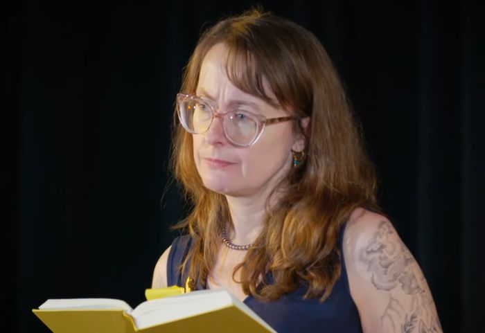 Emily Wilson, The Odyssey translator, in a thoughtful pose, with an open book, pointing out adaptation blunders.