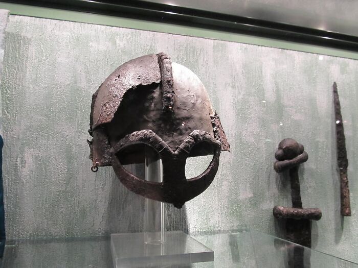 A historical Viking helmet with metal face guard, showcasing ancient artifacts and historical myths.