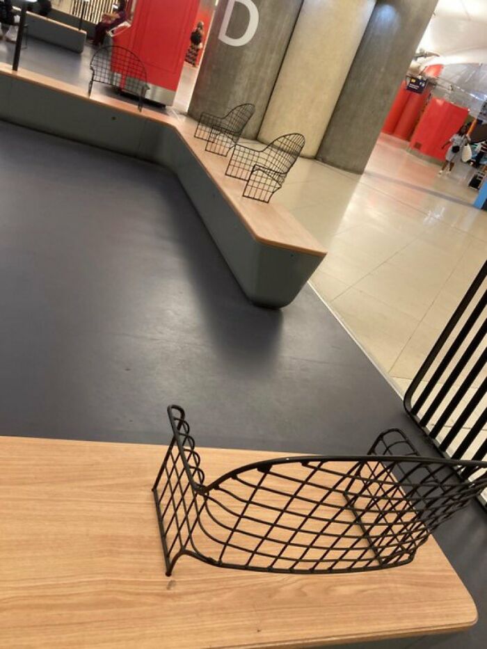 Urban designers forgot about people's comfort; a bench with uncomfortable wire seats in a public space.