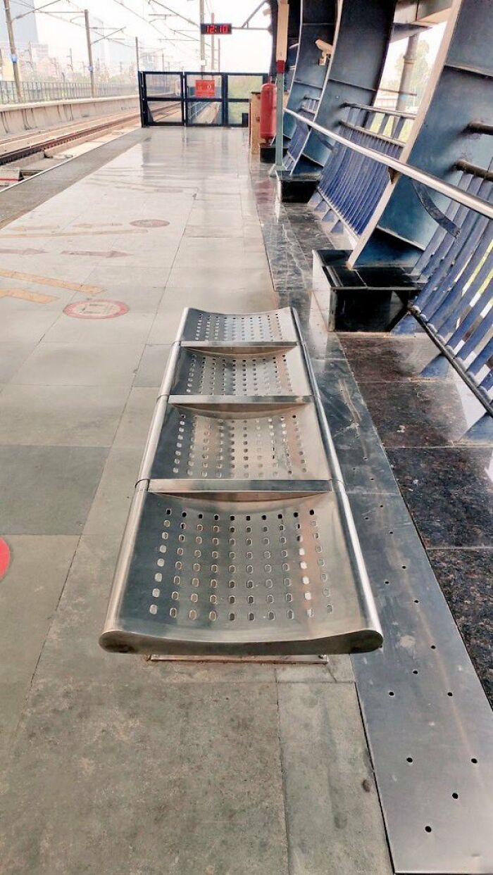 Hard metal seats at a subway platform, an example of urban designers' neglect of human comfort and happiness.