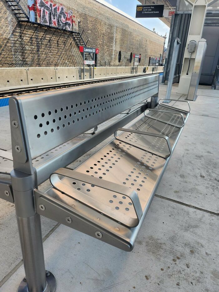 A metal bench with small, circular perforations and multiple armrests by urban designers, reducing people's comfort.