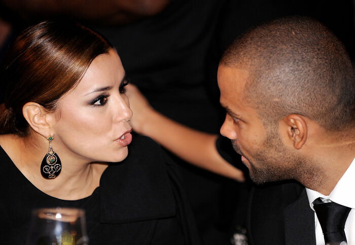 A man and a woman in formal attire engaged in conversation, relating to an alleged cheater.