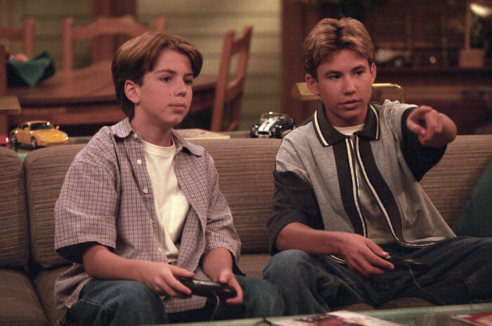 Two 90s child stars playing video games, a nostalgic scene before a disappointing reboot update. Two 90s child stars playing video games, a nostalgic scene before a disappointing reboot update.