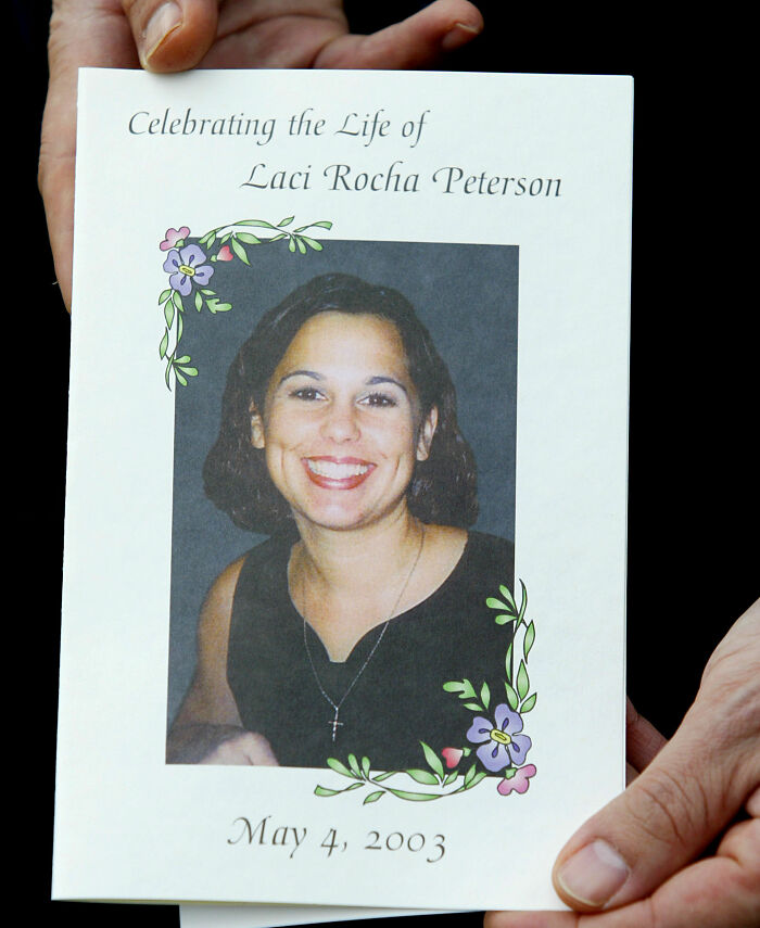 Hands holding a memorial program for Laci Peterson, the homicide victim, with her smiling photo and d***h date. Hands holding a memorial program for Laci Peterson, the homicide victim, with her smiling photo and d***h date.