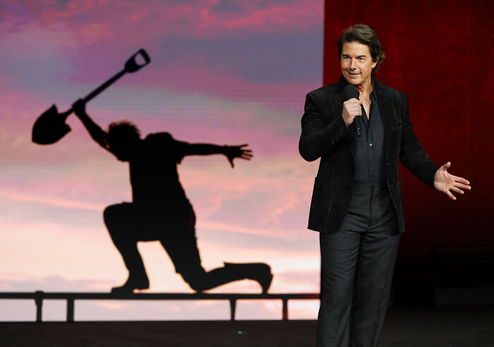 Tom Cruise on stage, highlighting his incredible transformation from an Oscar-worthy film.