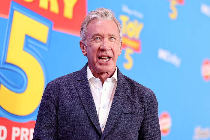 Tim Allen, a lead actor from a 90s show, at an event, after a disappointing reboot update, smiling. Tim Allen, a lead actor from a 90s show, at an event, after a disappointing reboot update, smiling.