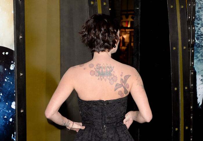 Actress Lena Headey from behind, showing back tattoos and avoiding exposing herself. Actress Lena Headey from behind, showing back tattoos and avoiding exposing herself.