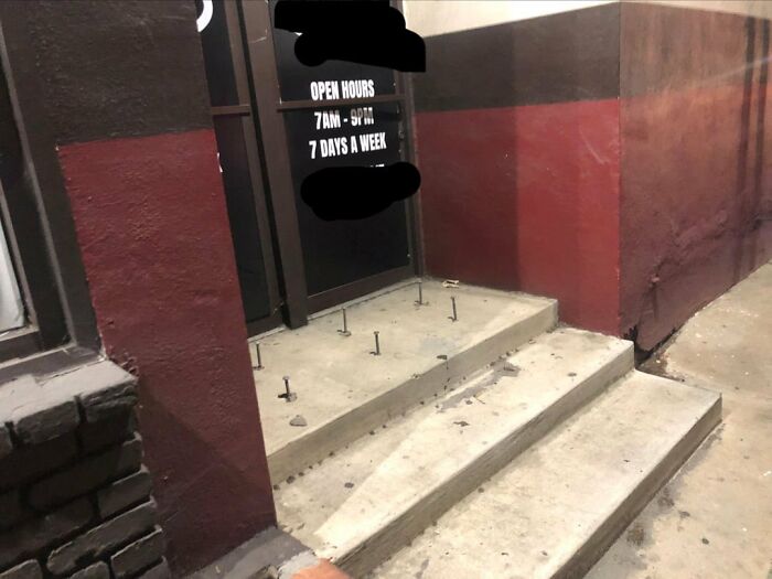 Metal spikes on concrete steps in front of a doorway, an example of urban designers not thinking about people.