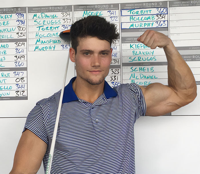 Image of the looksmaxxer posing with a golf club, flexing his bicep, in front of a competition bracket.