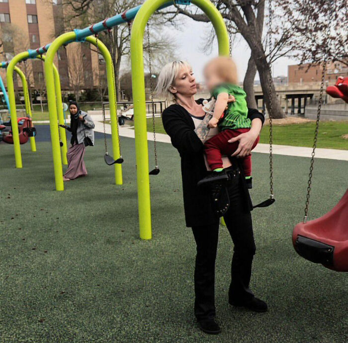 A White Minnesota mom holds a child on a playground, her fate uncertain after a racial slur incident. A White Minnesota mom holds a child on a playground, her fate uncertain after a racial slur incident.