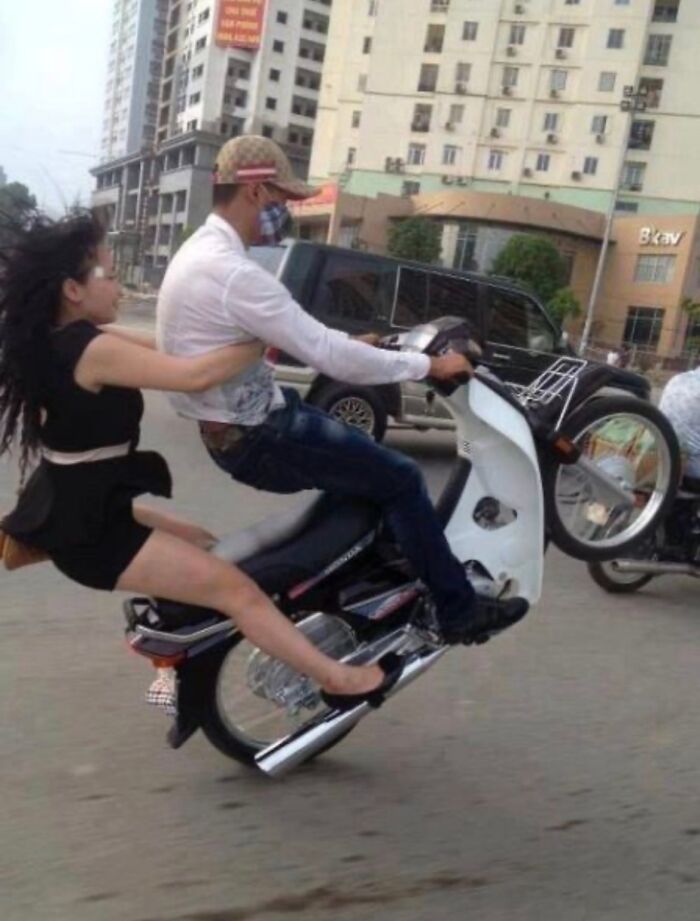 A hilarious photo taken moments before disaster struck: a couple on a motorbike doing a wheelie.