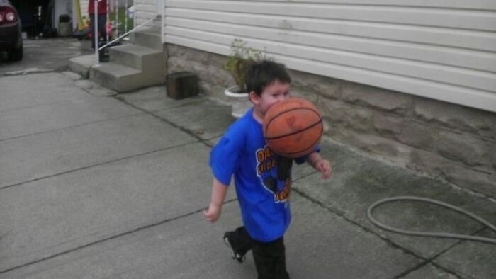 A boy takes a basketball to the face, a hilarious photo taken moments before disaster struck.