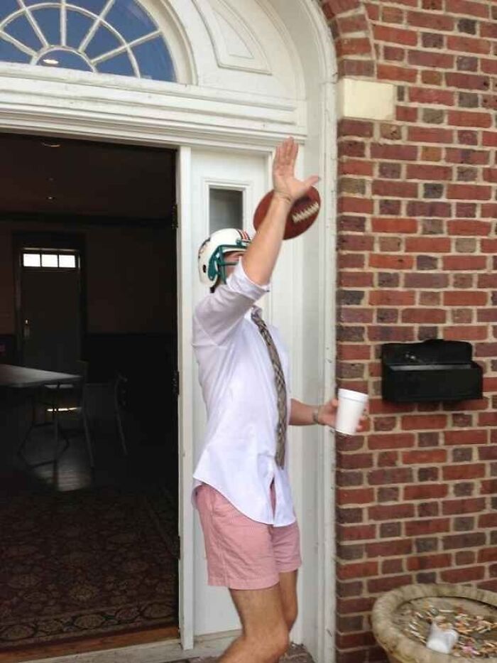 Hilarious photo of a man in a football helmet dropping a ball, moments before disaster.