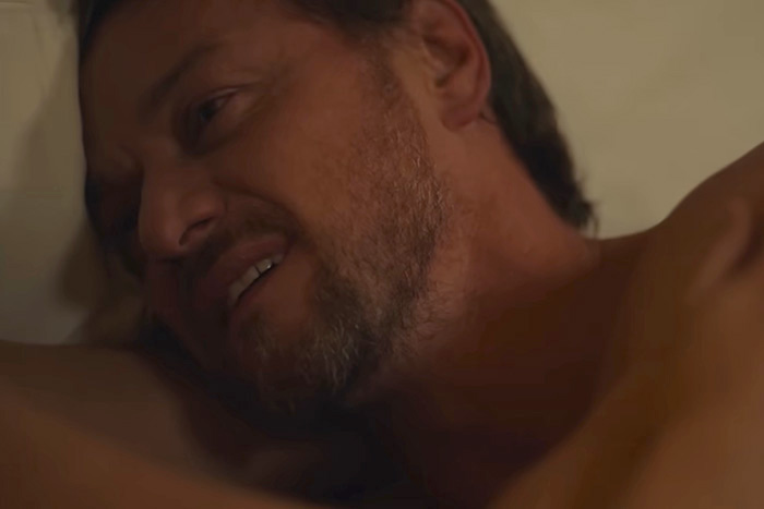 A man shown in an intimate scene, capturing the behind-the-scenes chaos.