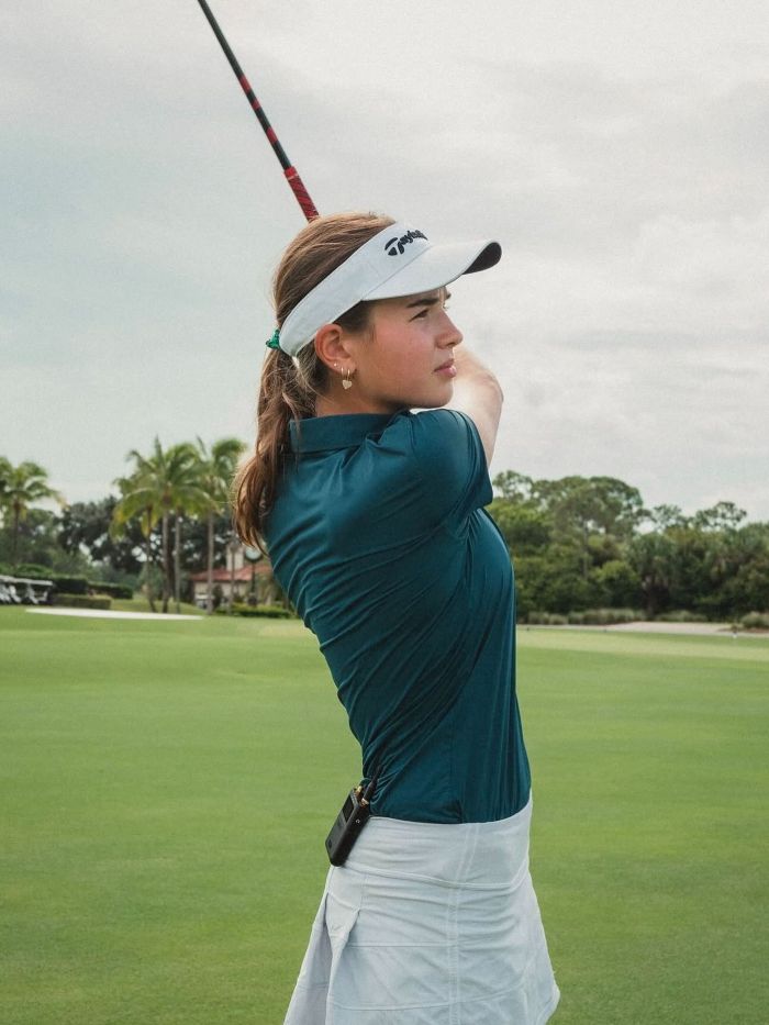 Kai Trump in a golf stance, mid-swing, showcasing her athletic side, prior to the ESPYs interview.