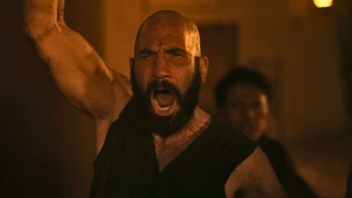 Christopher Nolan's Odyssey: A bearded man shouting with his arm raised in a new photo.