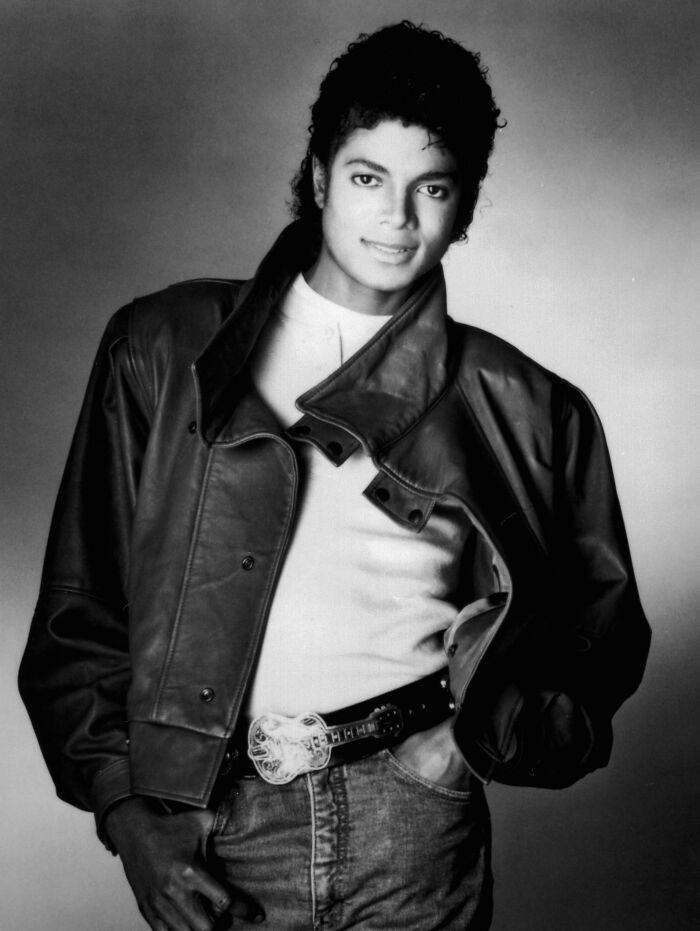 Michael Jackson in a leather jacket and jeans, in a black and white photo, representing fascinating things about the world.