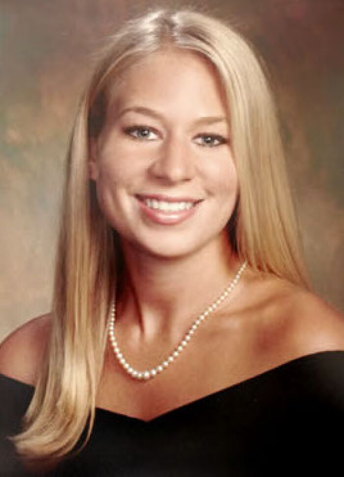 A headshot of a smiling young blonde woman in a pearl necklace, an unsolved mystery.