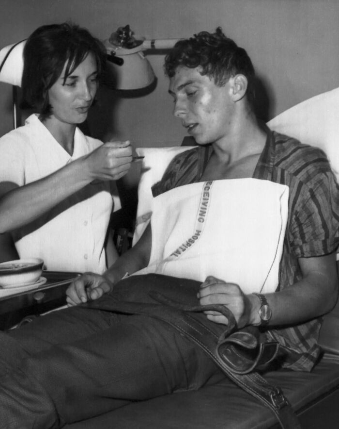 A black and white image of a nurse feeding a male patient in a hospital bed, offering a glimpse into the fascinating past.