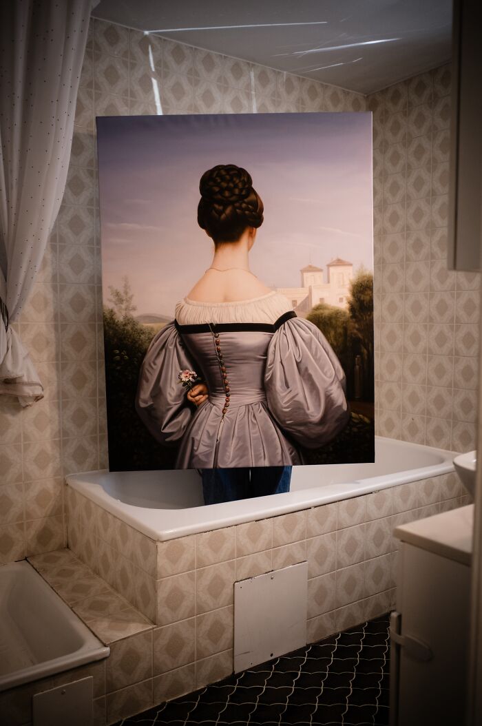 A masterpiece reimagined from behind: a painting of a woman in a grey dress with puffy sleeves standing in a bathtub.