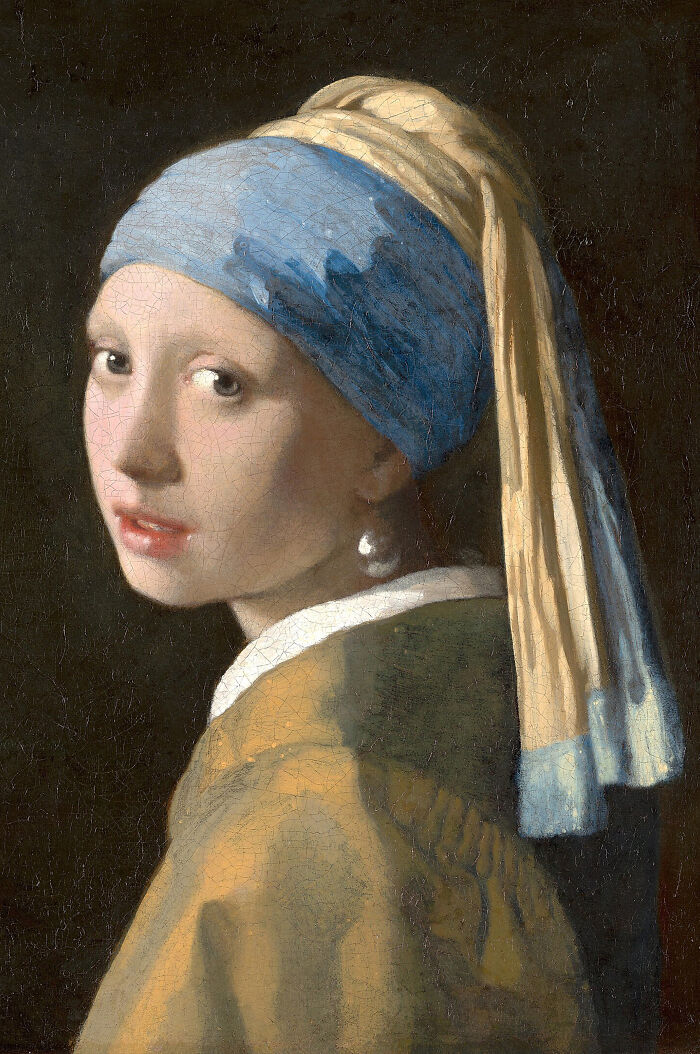 A person holds a reimagined masterpiece painting of Girl with a Pearl Earring from behind, standing in a bathtub.