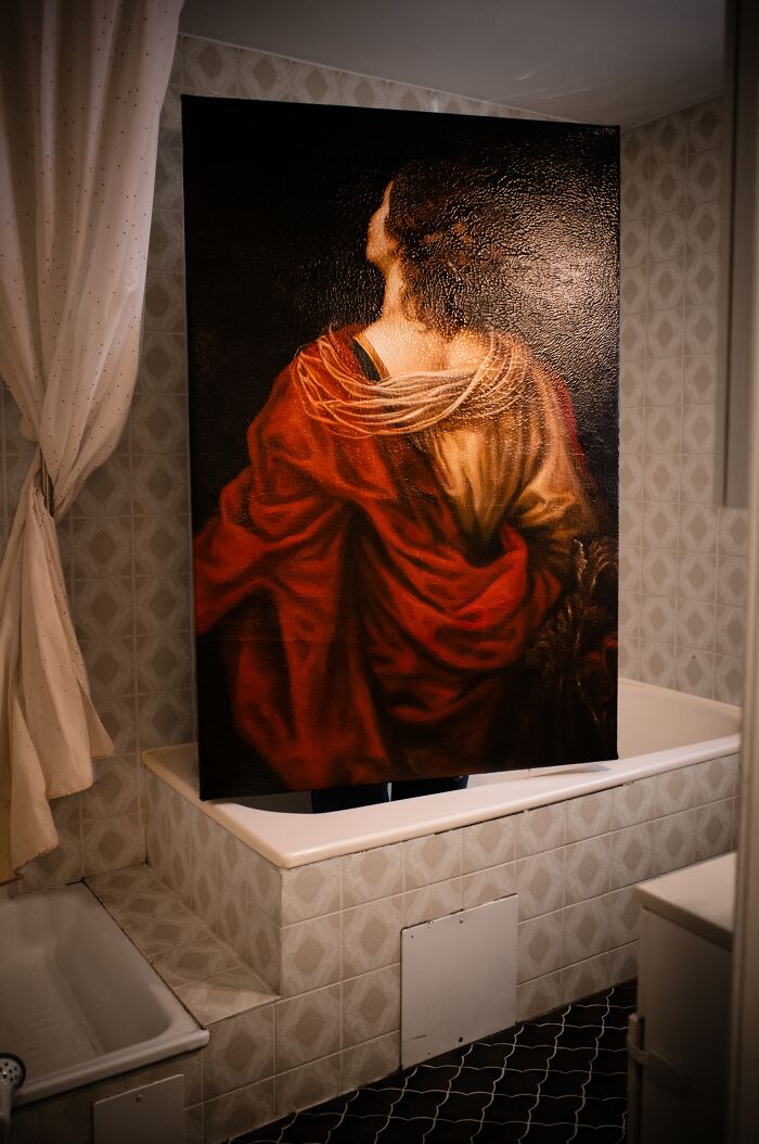 Artist reimagined a famous masterpiece from behind, presenting a figure draped in red fabric looking upwards.