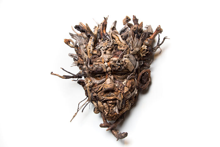 Stunning wood sculpture of a face with natural pieces collected by the artist, showing intricate detail and texture.