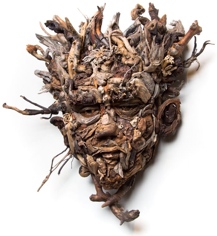 Stunning wood sculpture of a face with natural pieces collected by the artist, showing intricate detail and texture.
