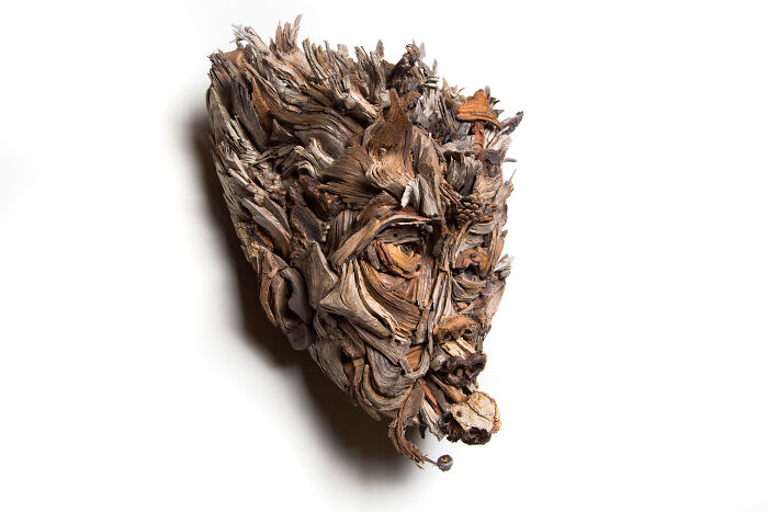 Unique wood sculpture, a profile of a face, artfully assembled from various pieces of wood.