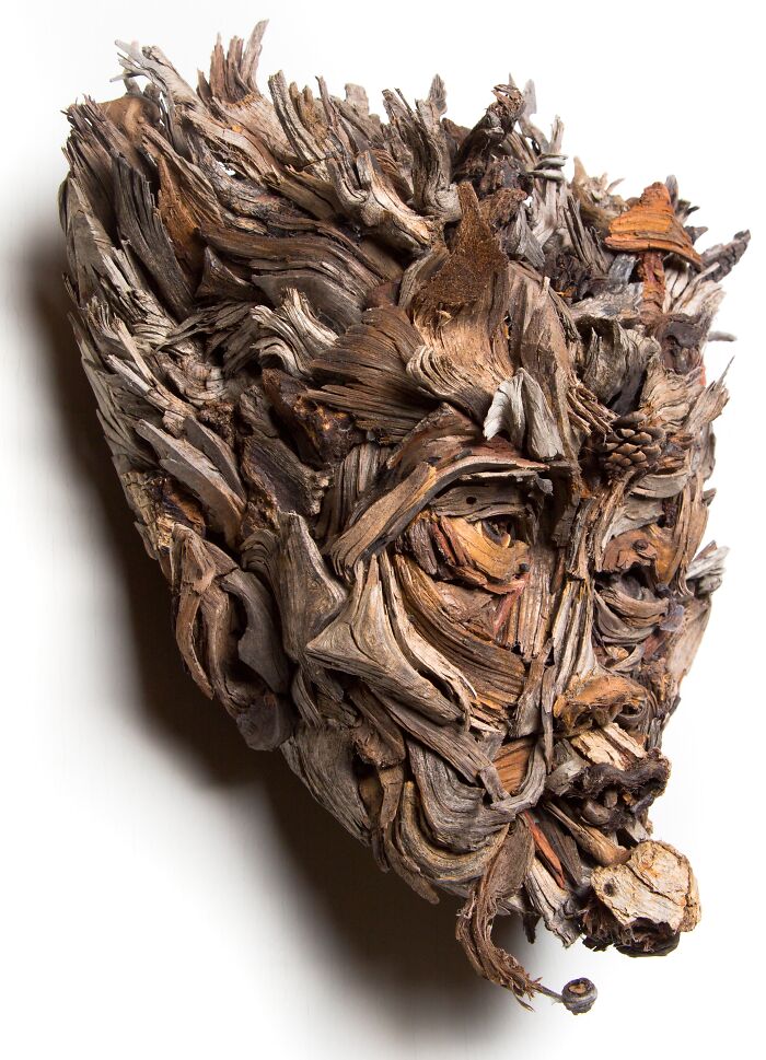 Unique wood sculpture, a profile of a face, artfully assembled from various pieces of wood.