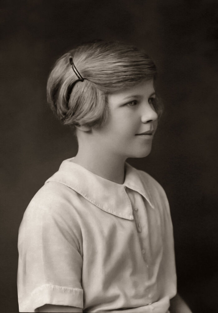 A sepia-toned portrait of a young girl with a short hairstyle, a fascinating image from the world.