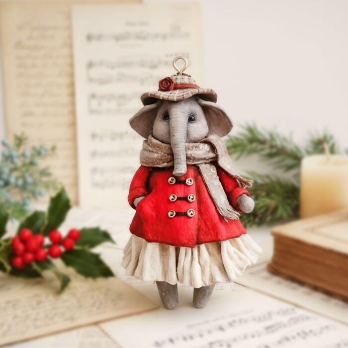 Delightful handmade cotton wool elephant in a red coat and scarf, an artist's creation.