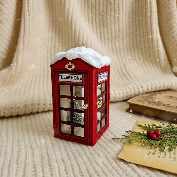 Handmade cotton wool creation of a red telephone booth ornament with snow and tiny Christmas trees.