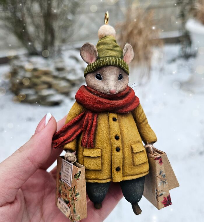 Cute handmade cotton wool mouse in winter attire carrying shopping bags, an artist's creation.