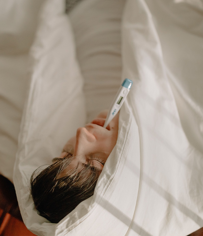 A person with a thermometer in their mouth, illustrating symptoms and the tragic loss of life from a bat encounter. A person with a thermometer in their mouth, illustrating symptoms and the tragic loss of life from a bat encounter.
