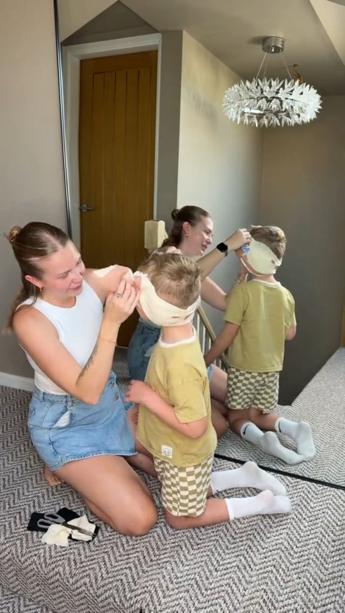 A mom adjusts a bandage on her 5YO boy before his cosmetic surgery, a controversial choice. A mom adjusts a bandage on her 5YO boy before his cosmetic surgery, a controversial choice.