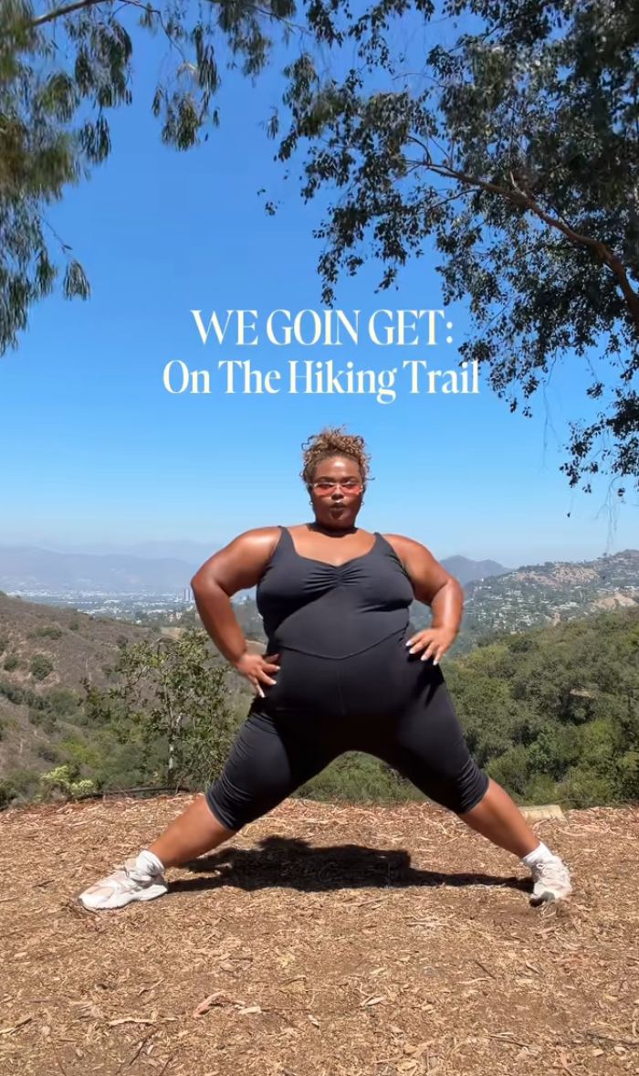 A plus size activist posing on a hiking trail in black athletic wear, highlighting an active lifestyle. A plus size activist posing on a hiking trail in black athletic wear, highlighting an active lifestyle.