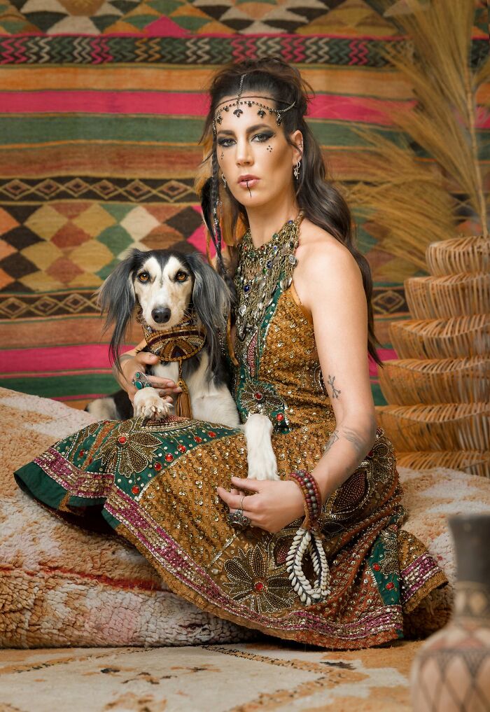 A woman in traditional attire holding a dog, a stunning entry in the Pet Photography Awards.