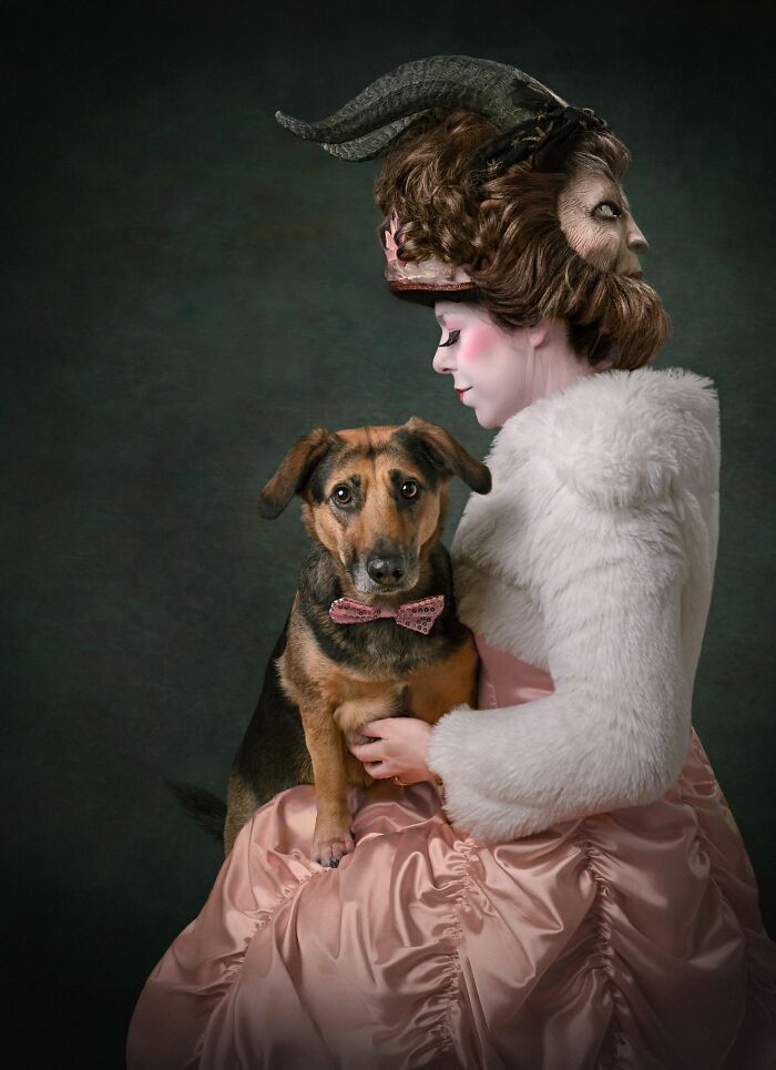 A woman with an elaborate hairstyle holding a dog wearing a bow tie, a favorite from the Pet Photography Awards.