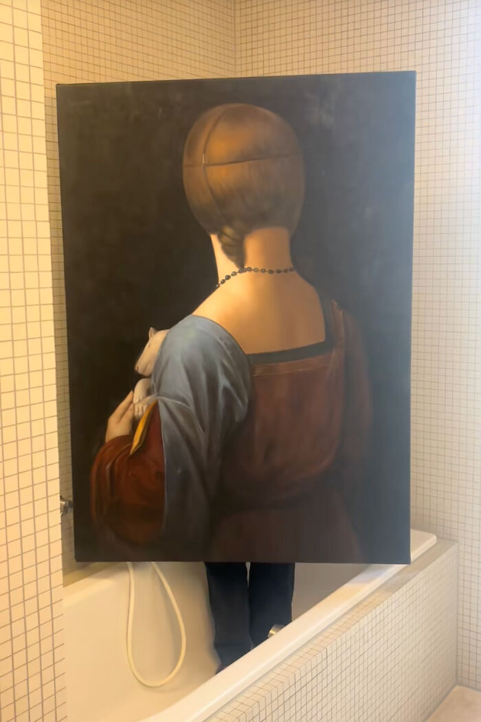 A masterpiece reimagined from behind: a painting of a woman in a red and blue dress holding an ermine, placed in a bathtub.