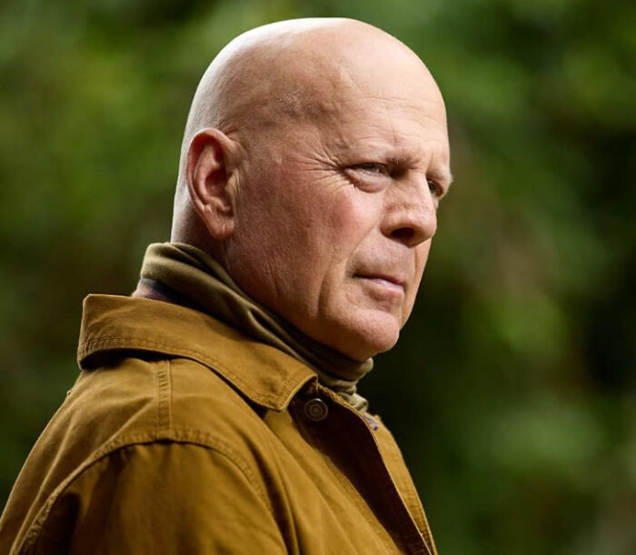 Bruce Willis, a celebrity, looking contemplative, outdoors in a brown jacket, displaying a serious expression, a favorite celebrity.