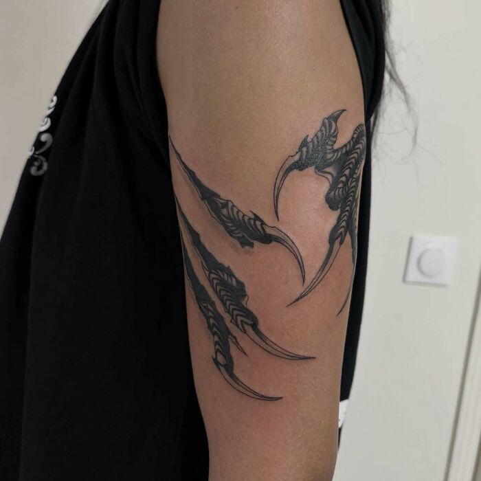 Claw mark tattoo art on an arm, showcasing creative design, inspiring examples.