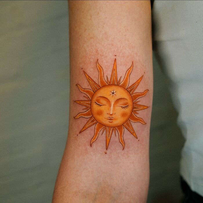 Vibrant sun tattoo art on an arm, showcasing inspiring examples of tattoo art.