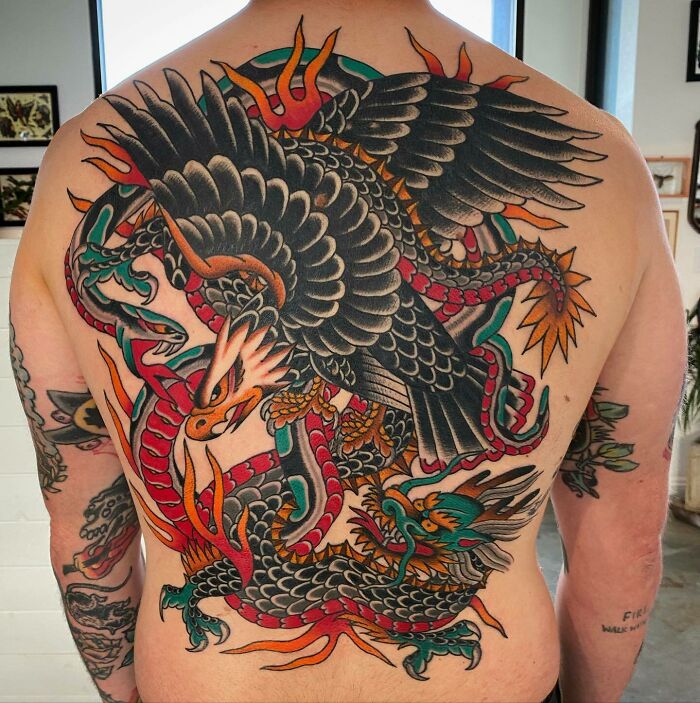 Vibrant full-back tattoo art featuring an eagle, dragon, and snake, showcasing inspiring tattoo art.