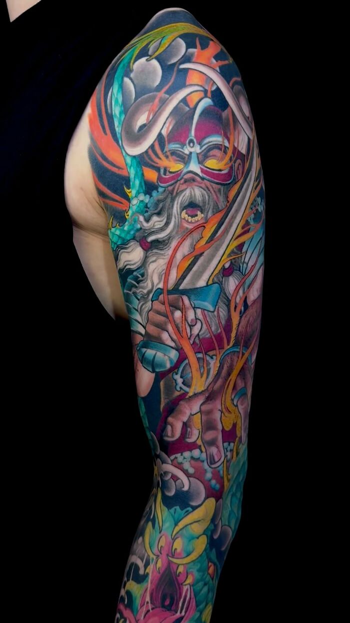 A detailed full sleeve tattoo art featuring a warrior with a sword amidst colorful flames and elements, showcasing inspiring tattoo art.
