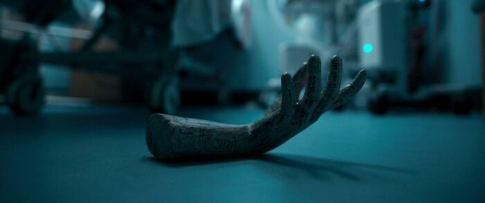 A disembodied, ancient-looking arm prop lies on a hospital floor, part of the most terrifying horror movies.