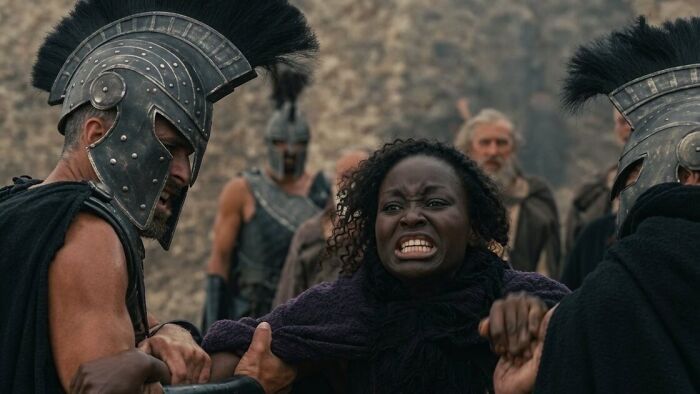 A distressed woman is held by two men in Spartan helmets, depicting the Age Gap in The Odyssey and Hollywood practice. A distressed woman is held by two men in Spartan helmets, depicting the Age Gap in The Odyssey and Hollywood practice.